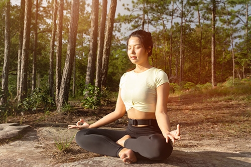 femme en méditation dans la forêt