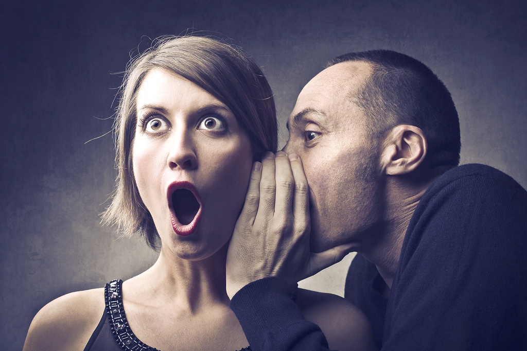 un homme chuchote un secret choquant à l'oreille d'une femme. effet sépia.